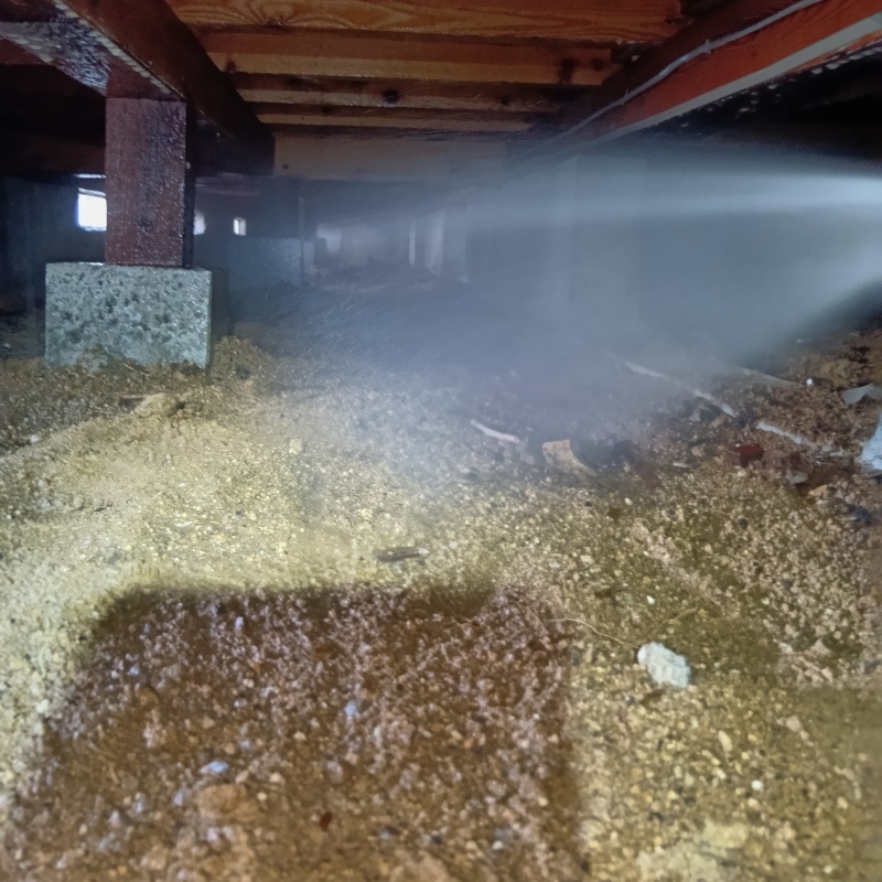 床下の土壌にシロアリ駆除剤を散布する様子