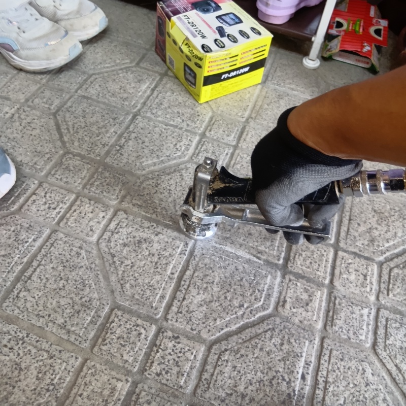 玄関の床にシロアリ駆除剤を注入する様子