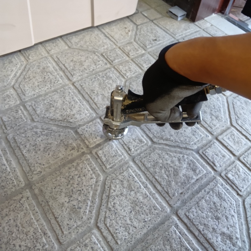 玄関の床にシロアリ駆除剤を注入する様子