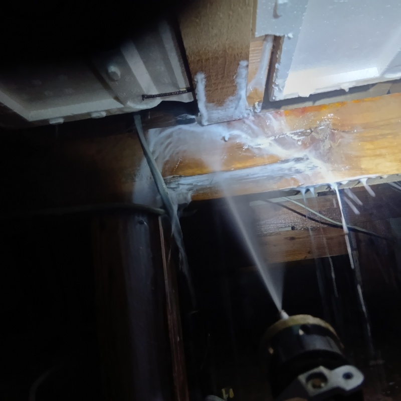 床下の木材にシロアリ駆除剤を散布する様子