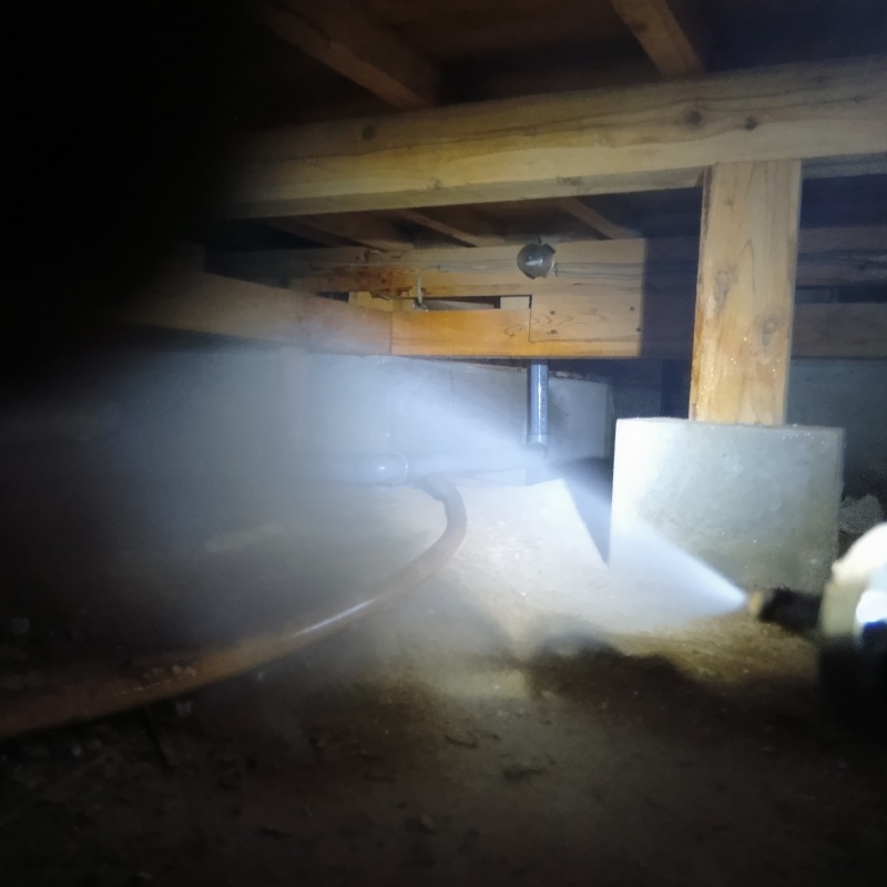 床下の土壌にシロアリ駆除剤を散布する様子