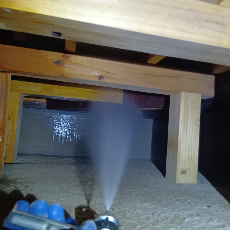 床下の基礎部分に防蟻剤を散布する様子