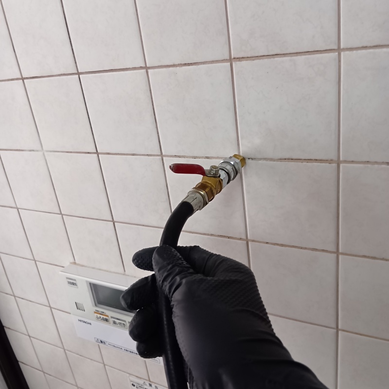 浴室の壁に防蟻剤を注入する様子