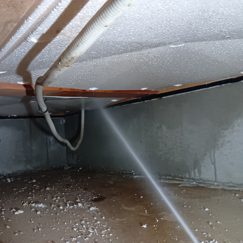 床下の木材にシロアリ駆除剤を散布する様子