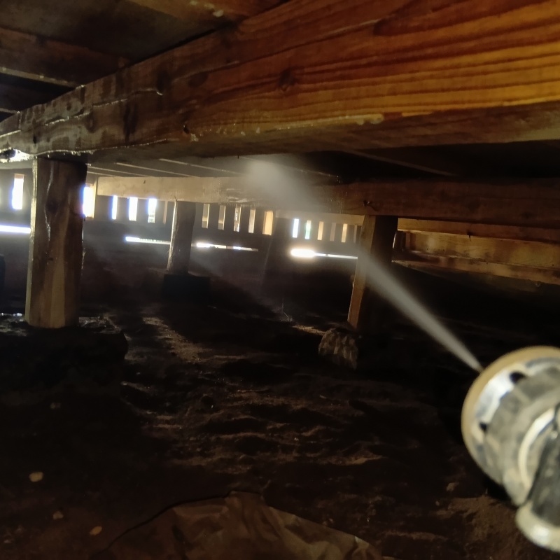 床下の木材にシロアリ駆除剤を散布する様子