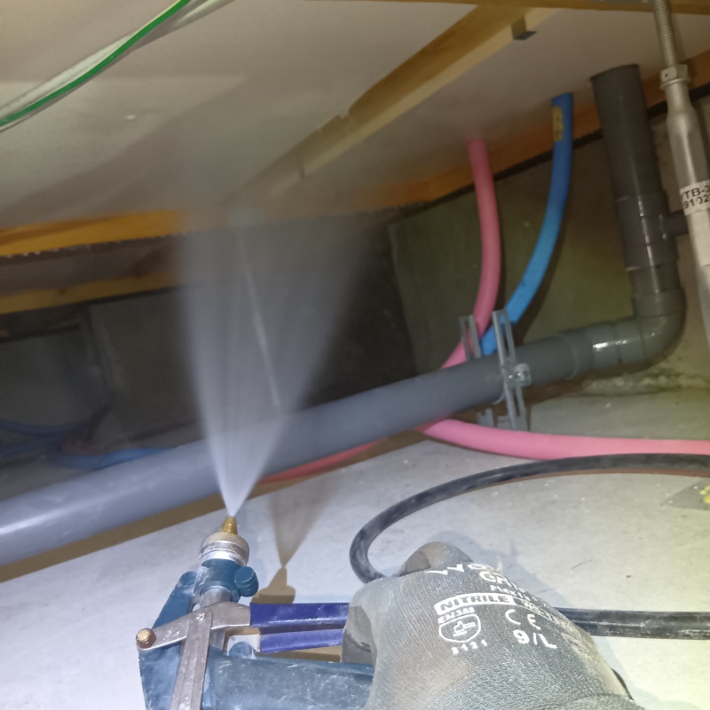 床下の木材に防蟻剤を散布する様子