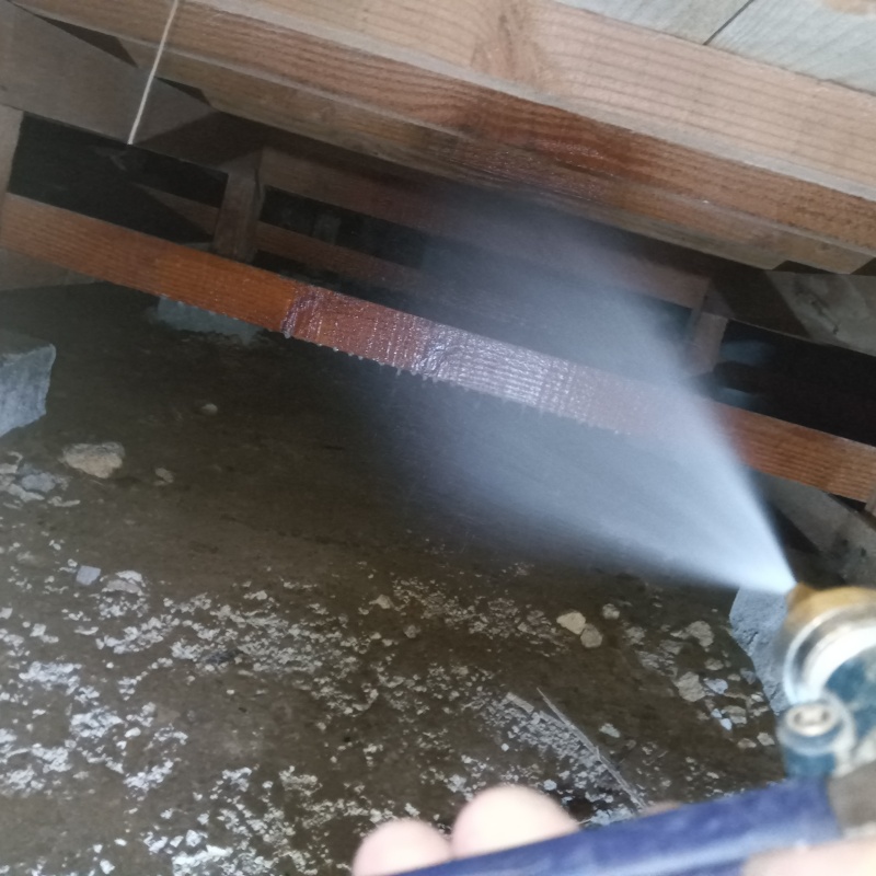 床下の木材にシロアリ駆除剤を散布する様子