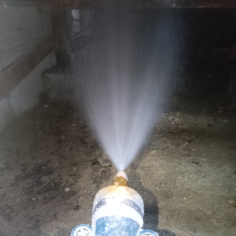 床下の土壌にシロアリ駆除剤を散布する様子