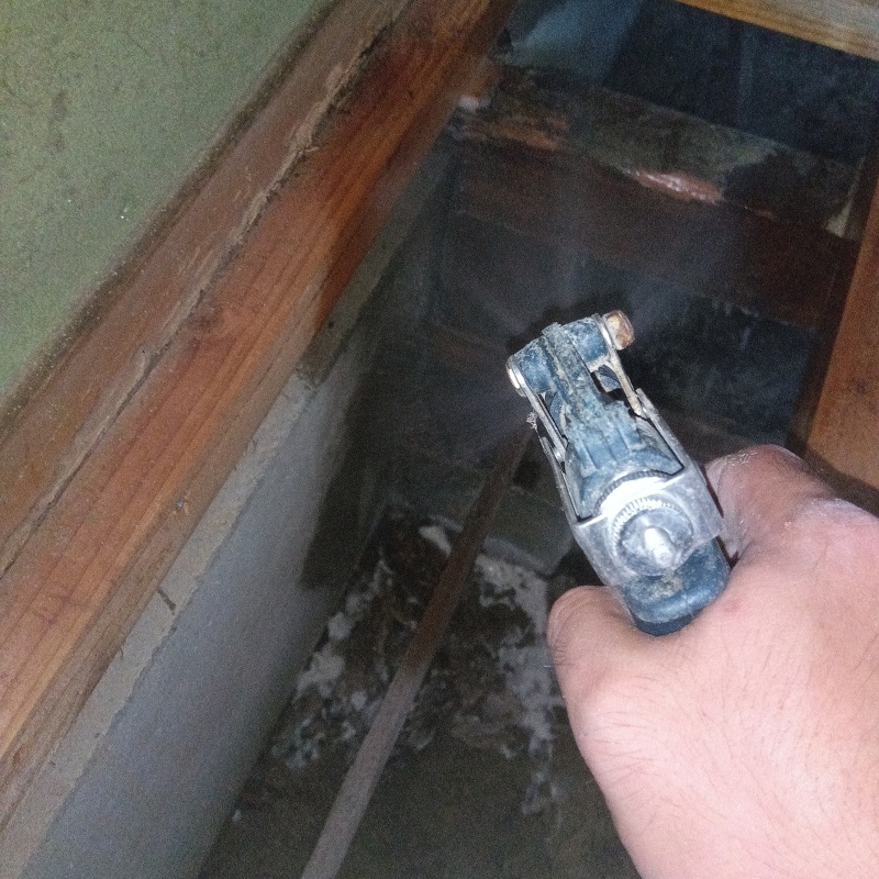 床下の基礎部分にシロアリ駆除剤を散布する様子