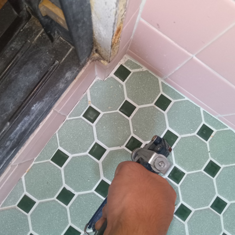 浴室の床にシロアリ駆除剤を注入する様子