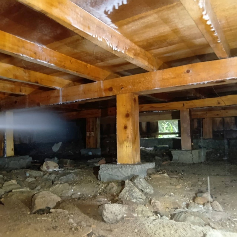 床下の木材にシロアリ駆除剤を散布する様子