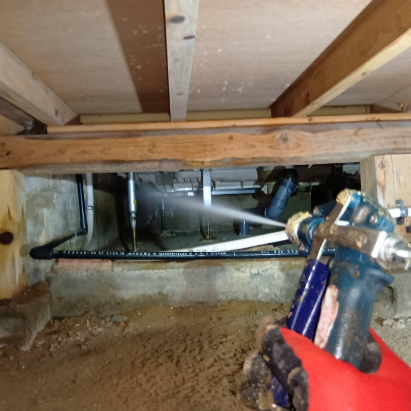 床下の基礎部分にシロアリ駆除剤を散布する様子