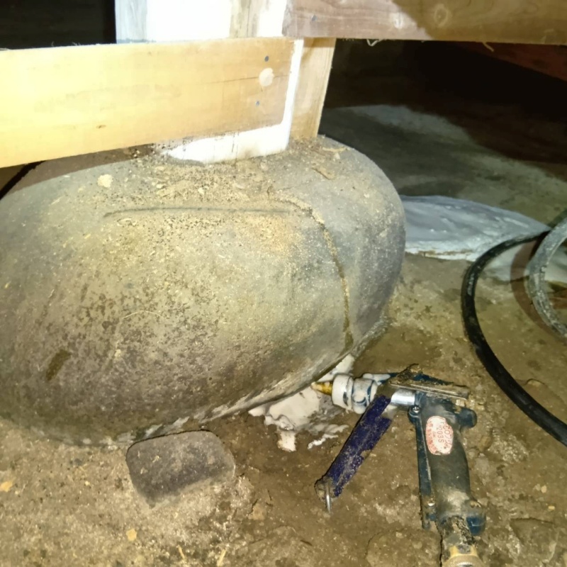 床下の基礎部分にシロアリ駆除剤を散布する様子