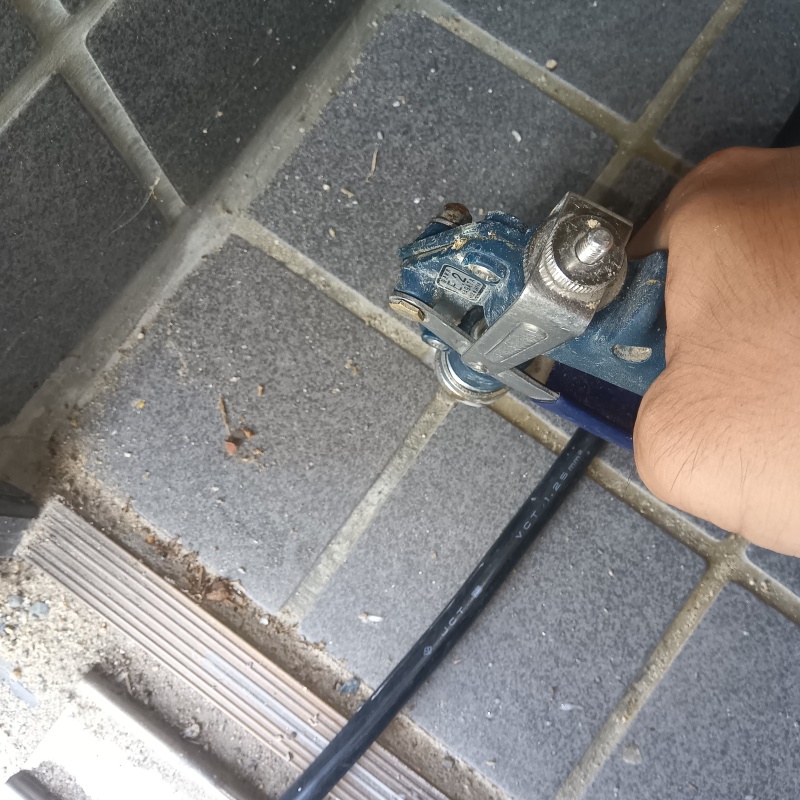 玄関の床にシロアリ駆除剤を注入する様子