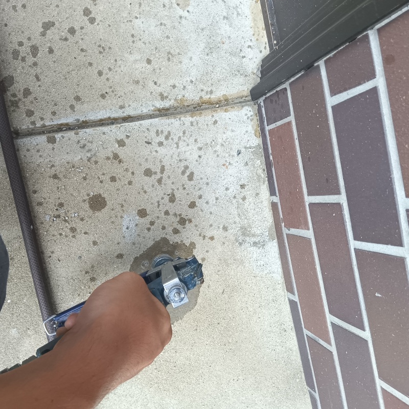 玄関の床にシロアリ駆除剤を注入する様子