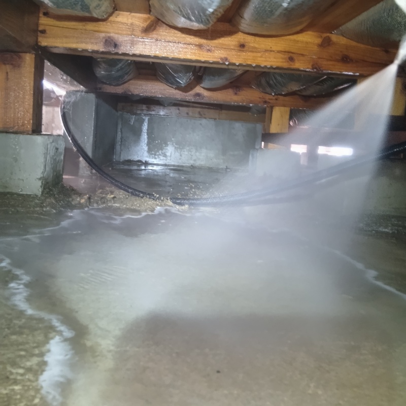 床下の基礎部分にシロアリ駆除剤を散布する様子