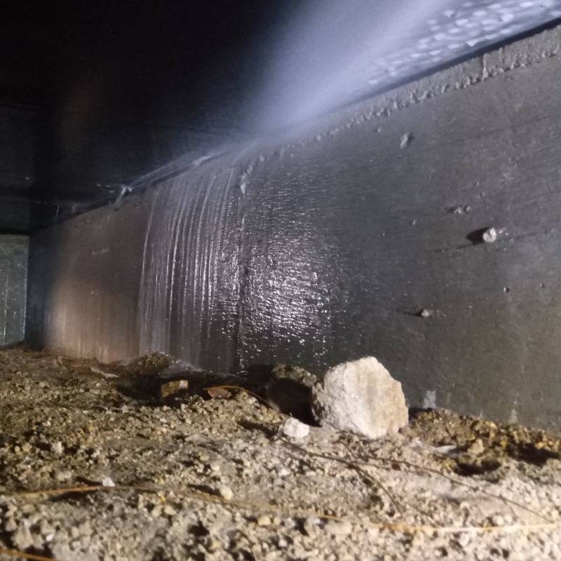 床下の基礎部分にシロアリ駆除剤を散布する様子