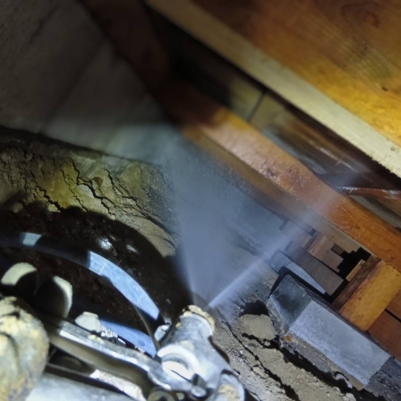 食害を受けた床下の木材にシロアリ駆除剤を散布する様子