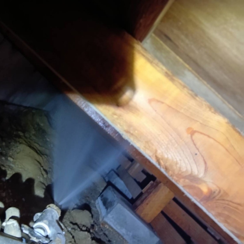 床下の木材にシロアリ駆除剤を散布する様子