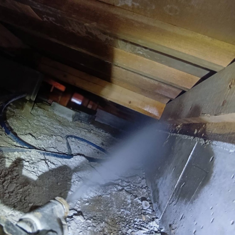 床下の土壌にシロアリ駆除剤を散布する様子