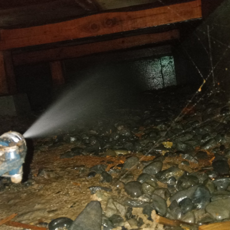 床下の基礎部分にシロアリ駆除剤を散布する様子