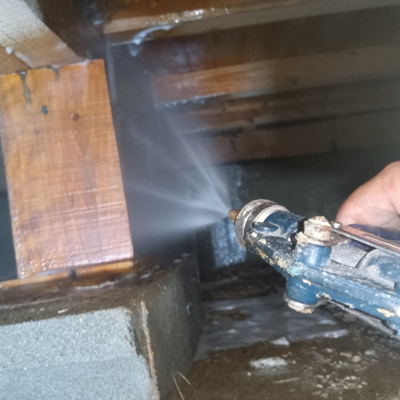 床下の木材にシロアリ駆除剤を散布する様子