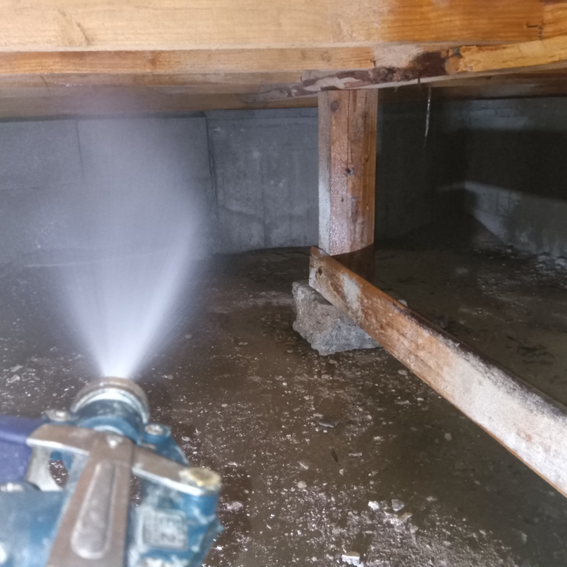 床下の基礎部分にシロアリ駆除剤を散布する様子
