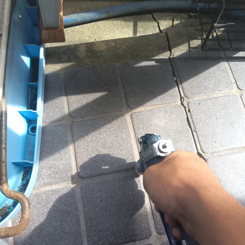 玄関の床にシロアリ駆除剤を注入する様子