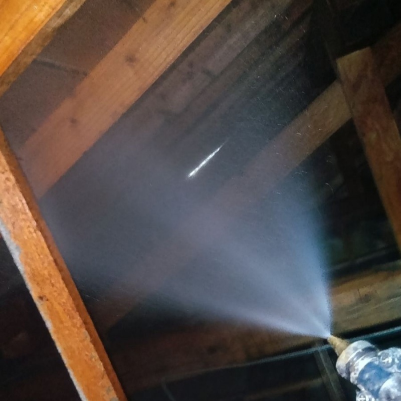 床下の木材にシロアリ駆除剤を散布する様子