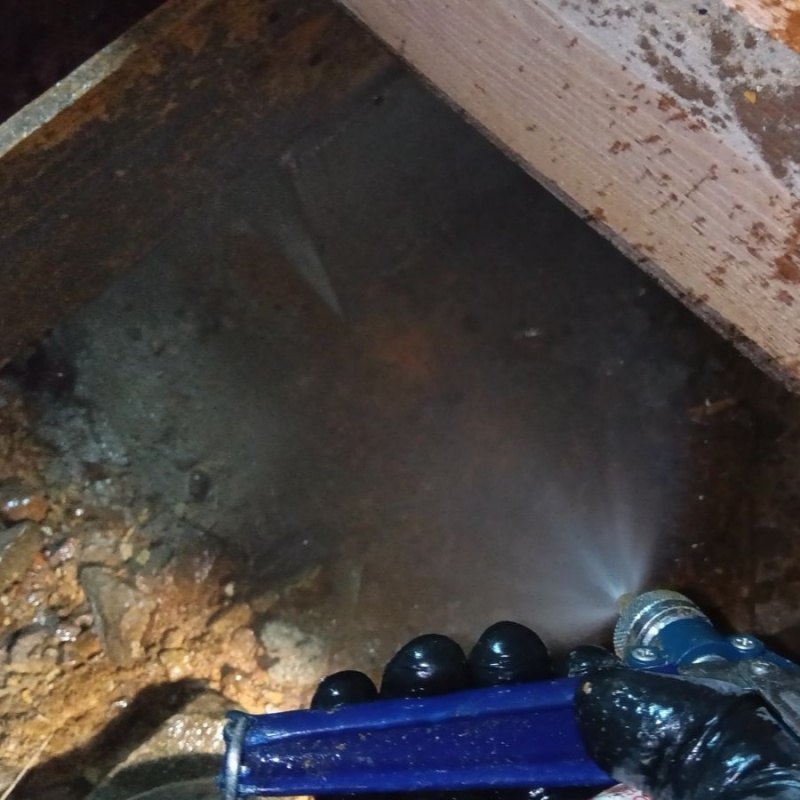 床下の土壌にシロアリ駆除剤を散布する様子