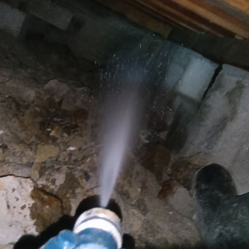 床下の基礎部分にシロアリ駆除剤を散布する様子