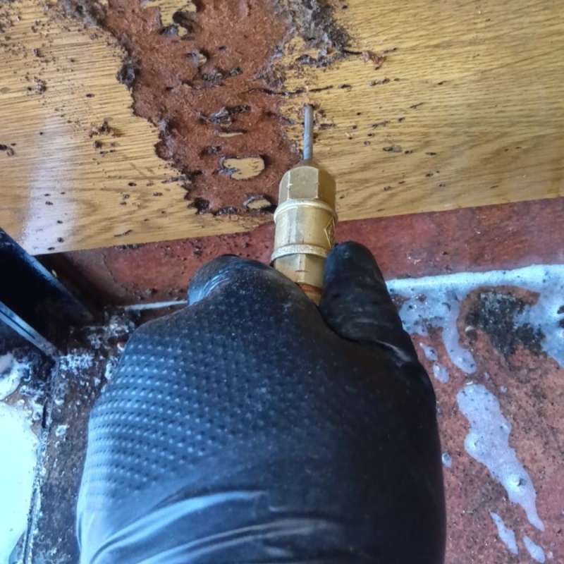 玄関の壁にシロアリ駆除剤を注入する様子