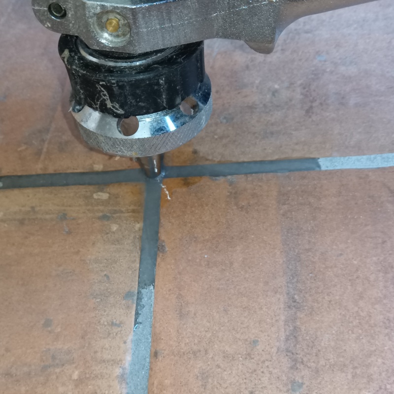 玄関の床にシロアリ駆除剤を注入する様子