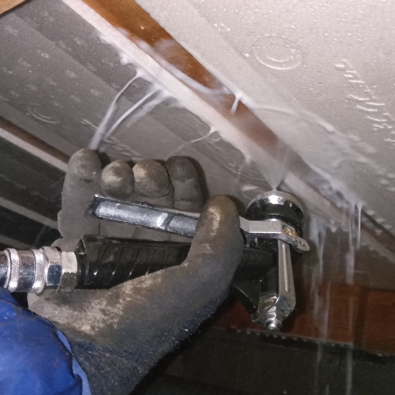 床下の木材にシロアリ駆除剤を散布する様子