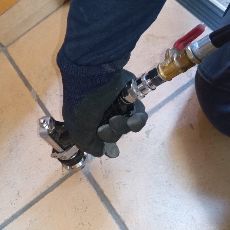 玄関の床にシロアリ駆除剤を注入する様子