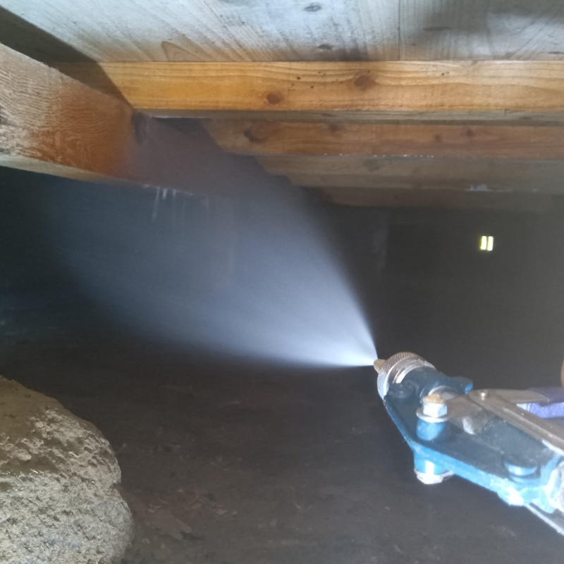 床下の木材にシロアリ駆除剤を散布する様子