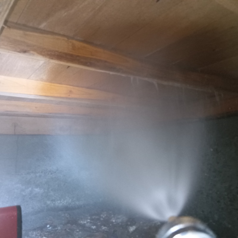 床下の木材にシロアリ駆除剤を散布する様子