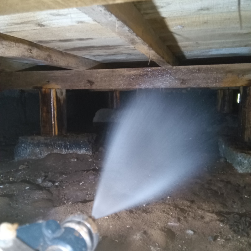 基礎まわりにシロアリ駆除剤を散布する様子