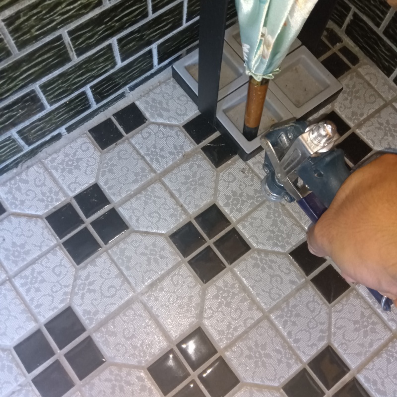 玄関の床にシロアリ駆除剤を注入する様子