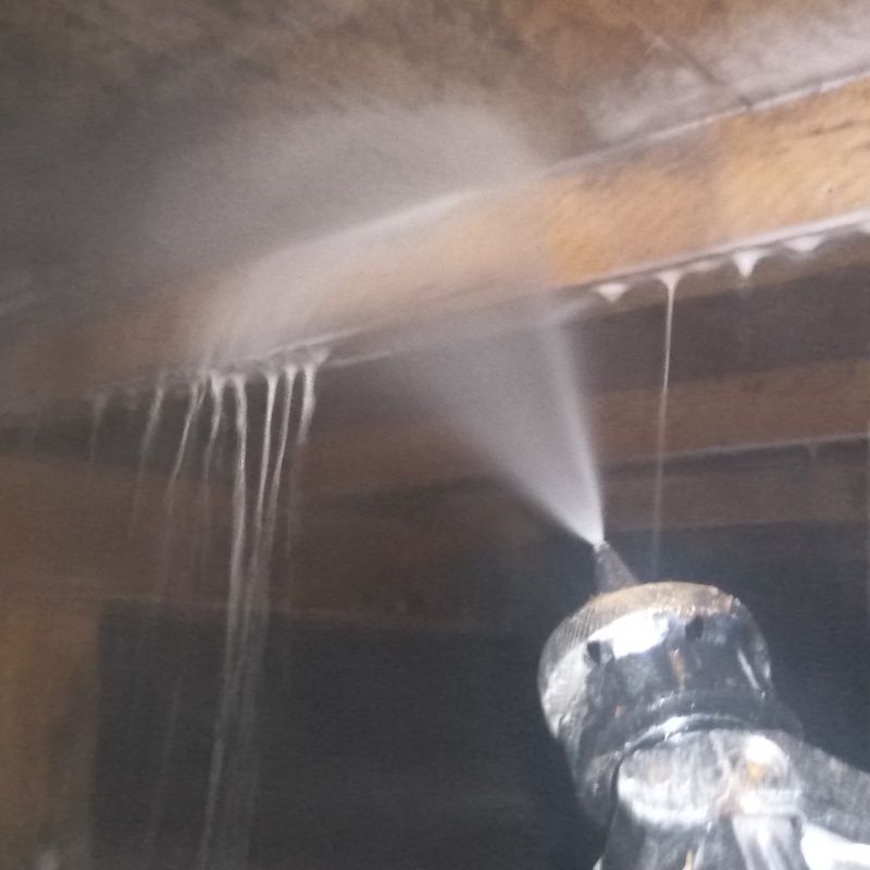 床下の木材にシロアリ駆除剤を散布する様子