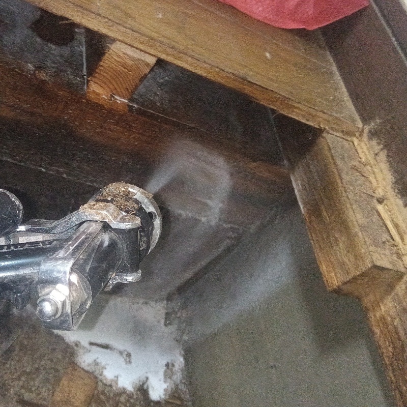 床下の木材にシロアリ駆除剤を散布する様子