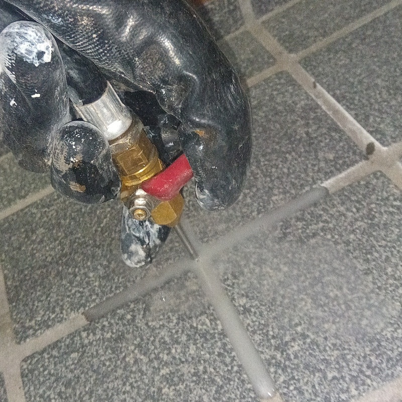 玄関の床にシロアリ駆除剤を注入する様子