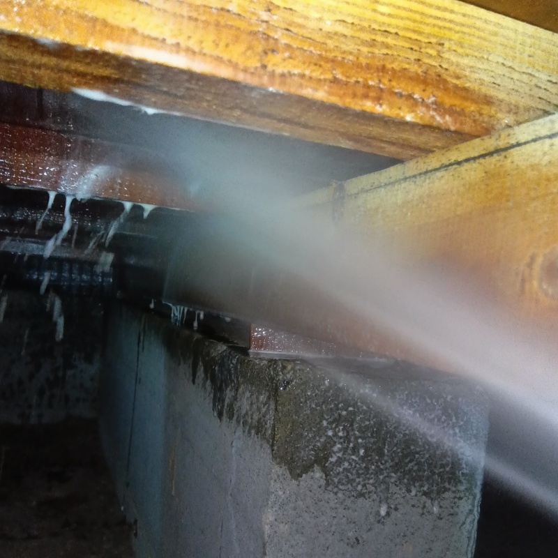 床下の木材にシロアリ駆除剤を散布する様子