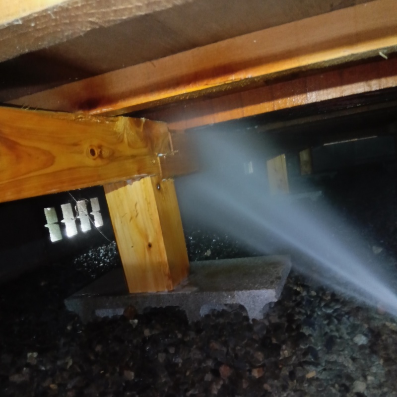 床下の木材にシロアリ駆除剤を散布する様子