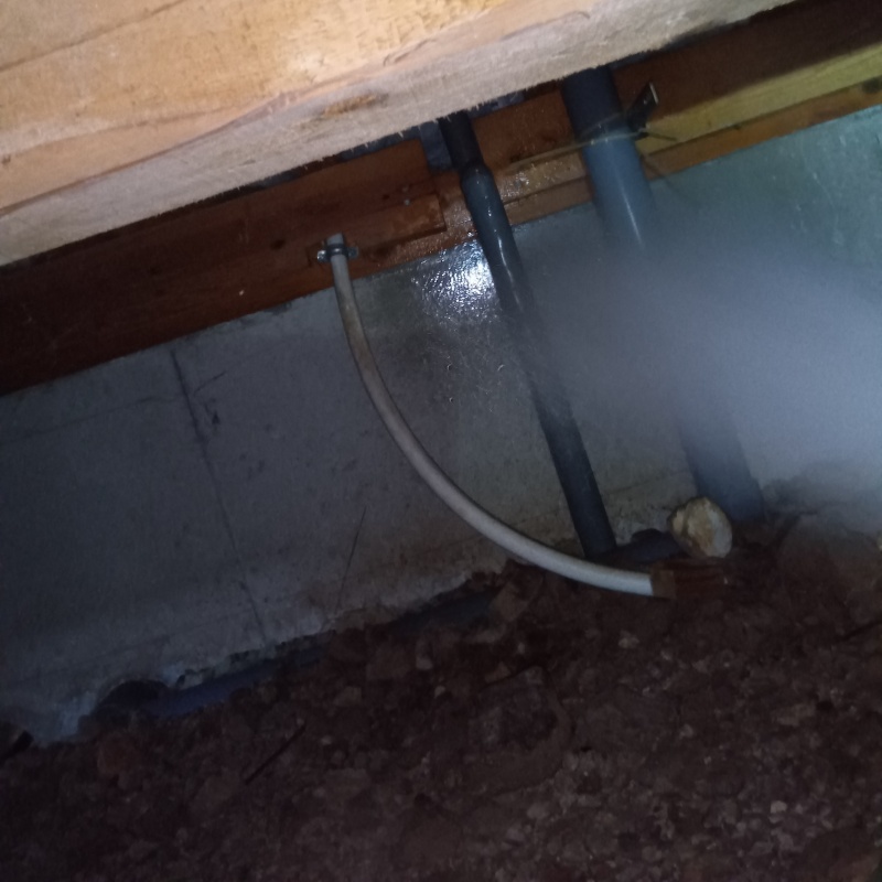 床下の基礎部分にシロアリ駆除剤を散布する様子