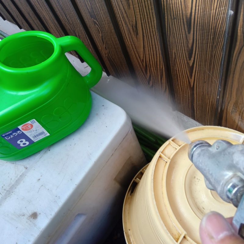 基礎まわりにシロアリ駆除剤を散布する様子