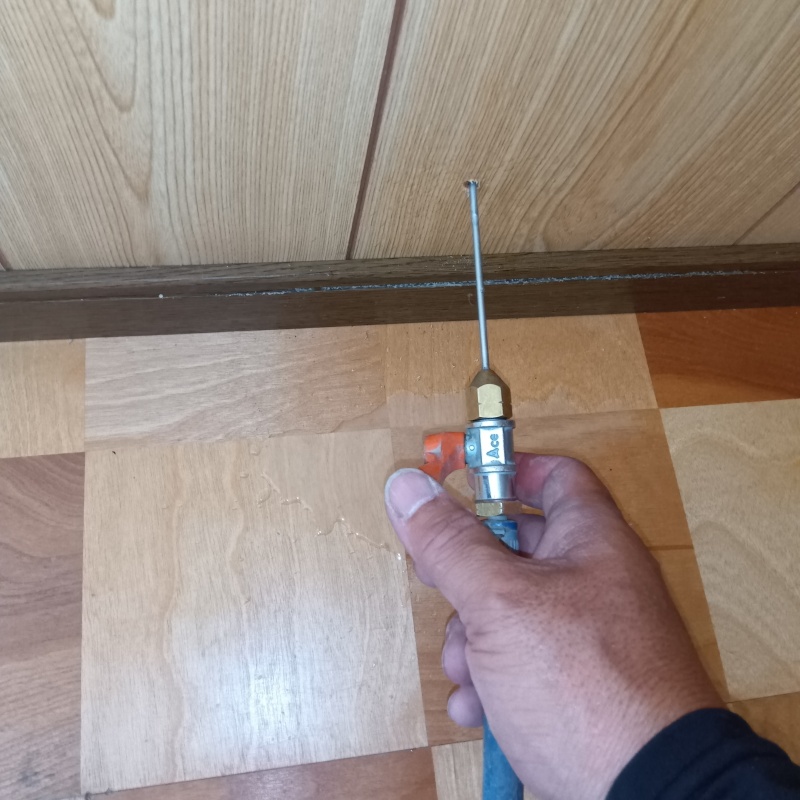 玄関近くの壁にシロアリ駆除剤を注入する様子