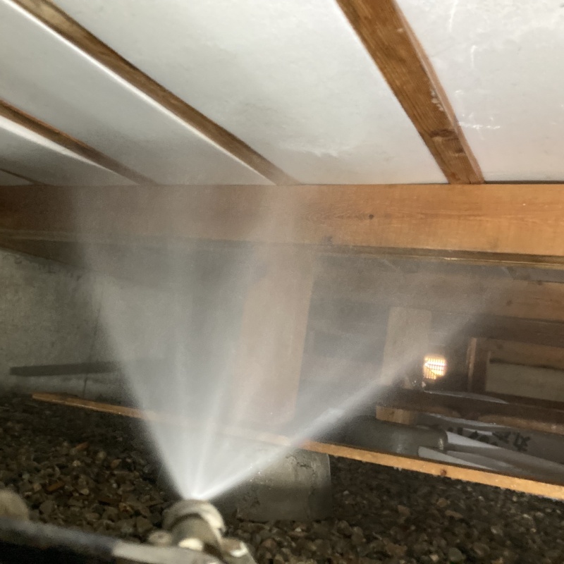 床下の木材にシロアリ駆除剤を散布する様子