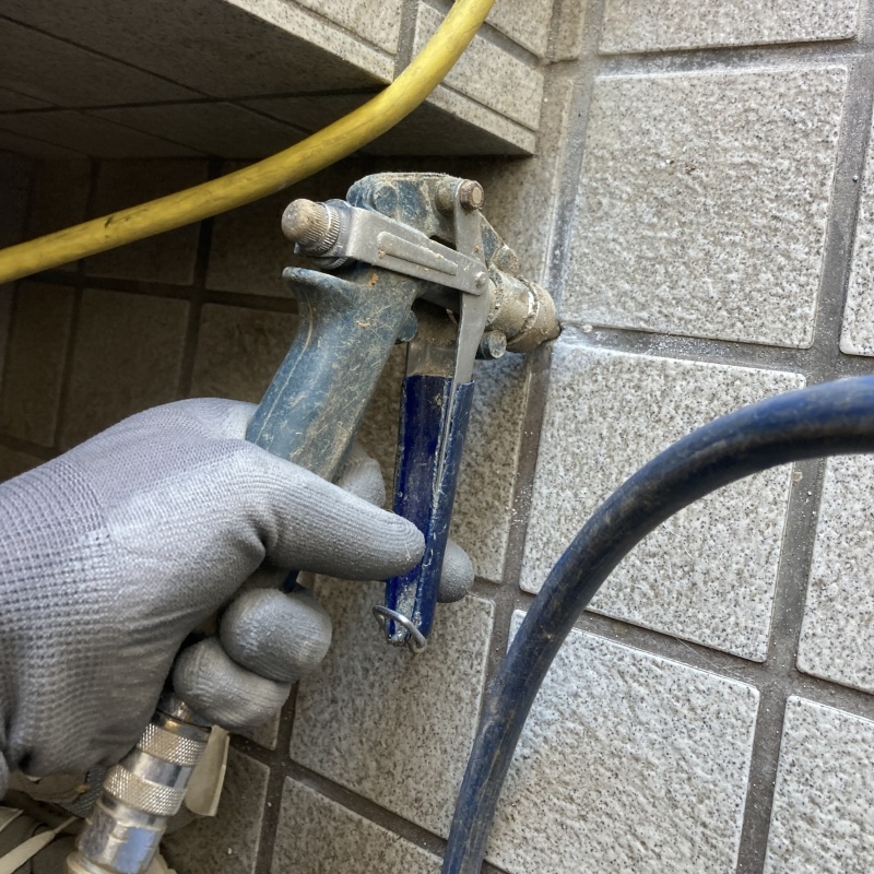 玄関の床にシロアリ駆除剤を注入する様子