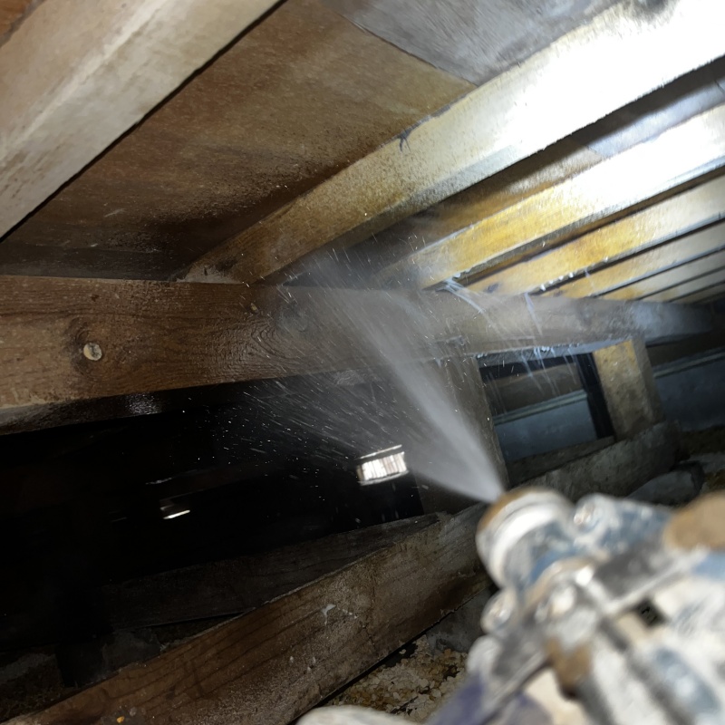 床下の木材に防蟻剤を散布する様子